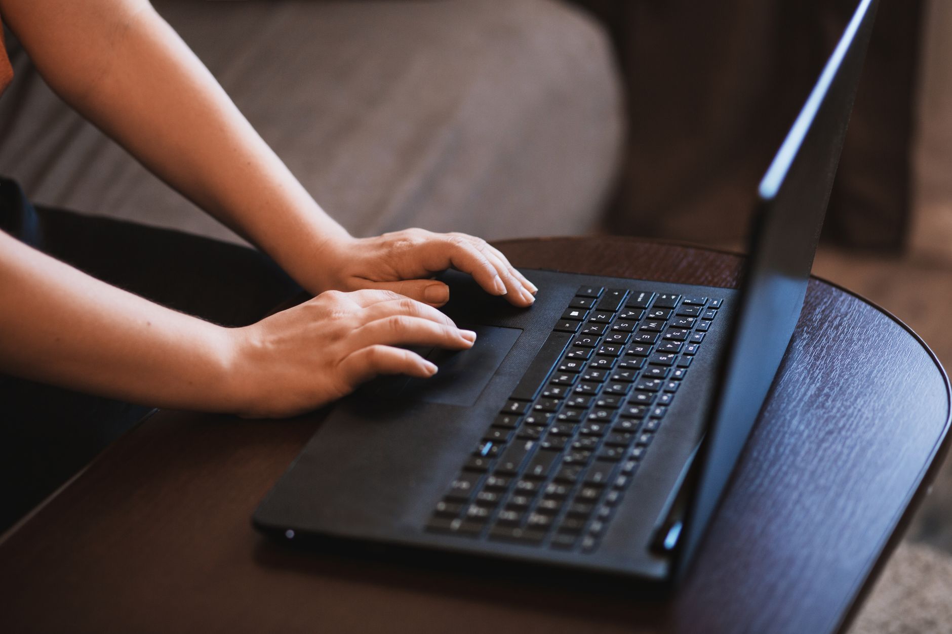 Nærbillede af hænder, der skriver på en bærbar computer, med fokus på det praktiske arbejde.
